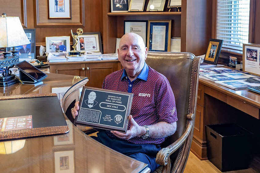 Vitale proudly holds his Sports Club of Tampa Bay Hall of Fame plaque, one of dozens honoring his impact on sports and philanthropy.